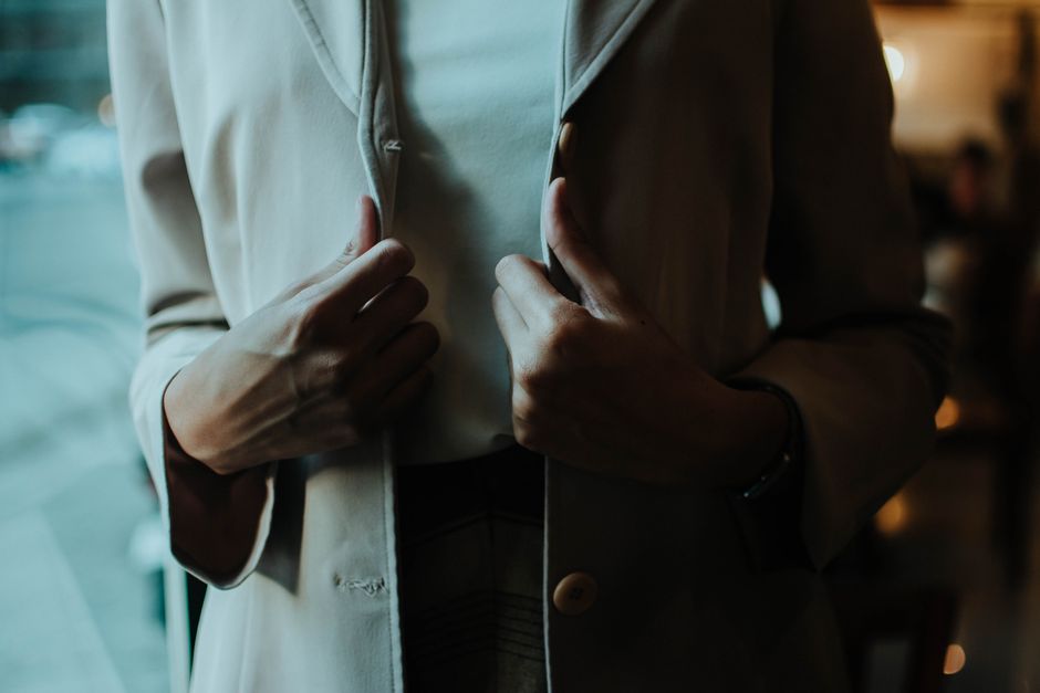 A close-up of a person demonstrating the American Sign Language sign for crying, with index fingers tracing paths down their cheeks and a sad facial expression.