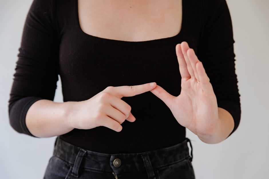 Step-by-step illustration showing the handshapes and movement for signing the word "cake" in ASL